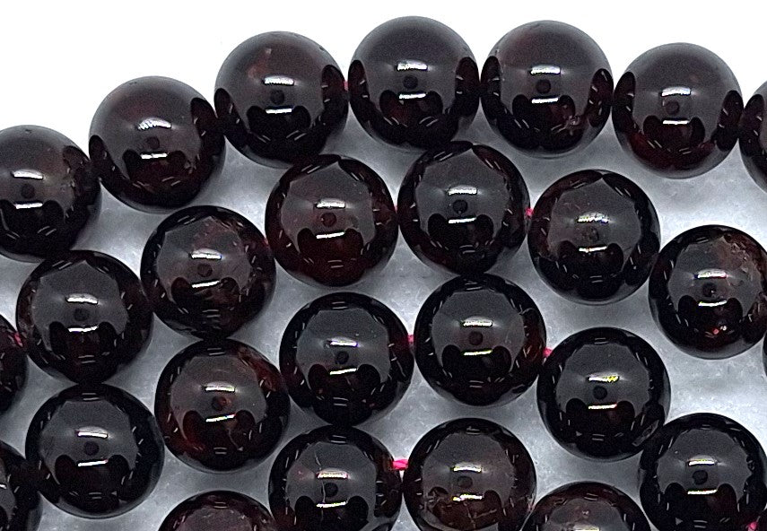 Close-up of dark purple beads on a white background