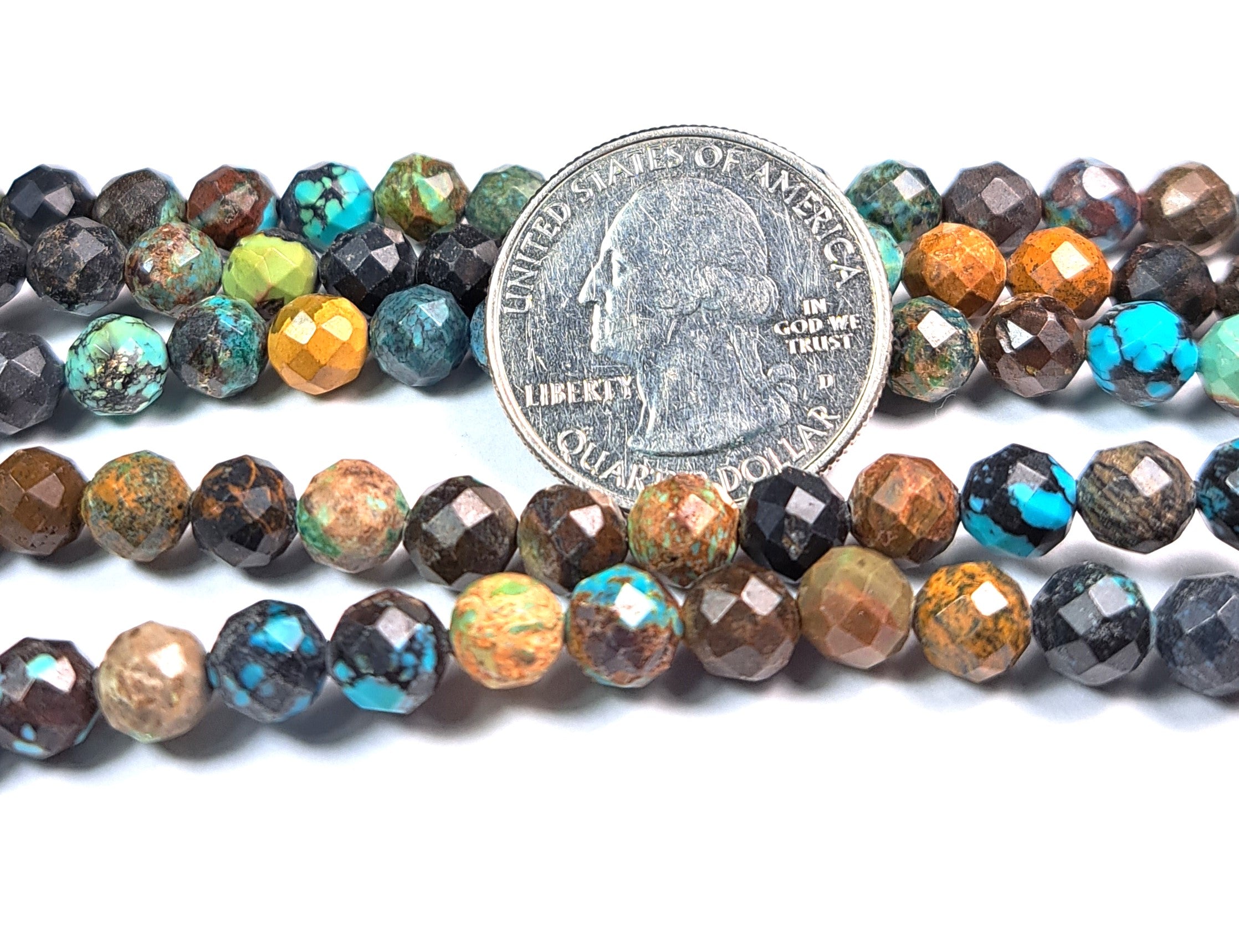 A strand of multicolored faceted round chrysocolla gemstone beads next to a coin for size comparison.