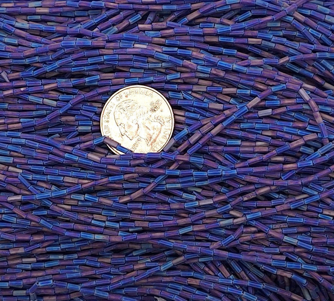 Close-up of blue and purple beadwork with a coin for scale